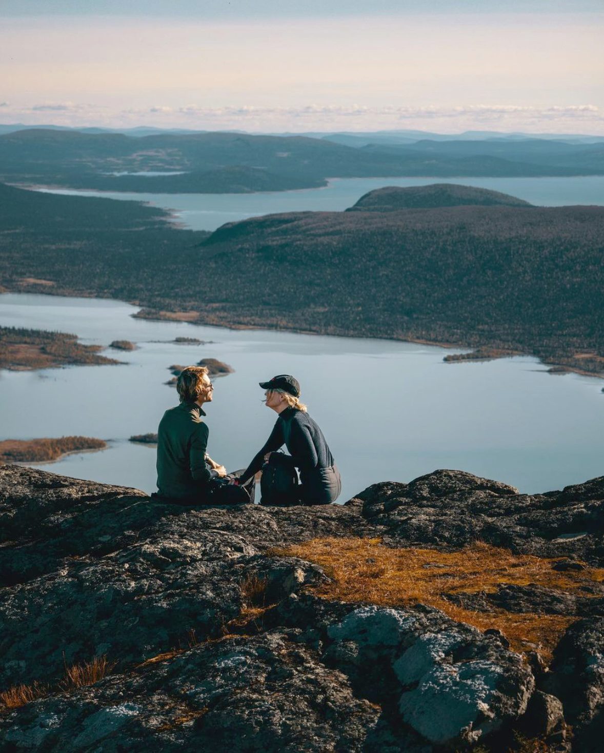 Two hikers resting above a mountain lake