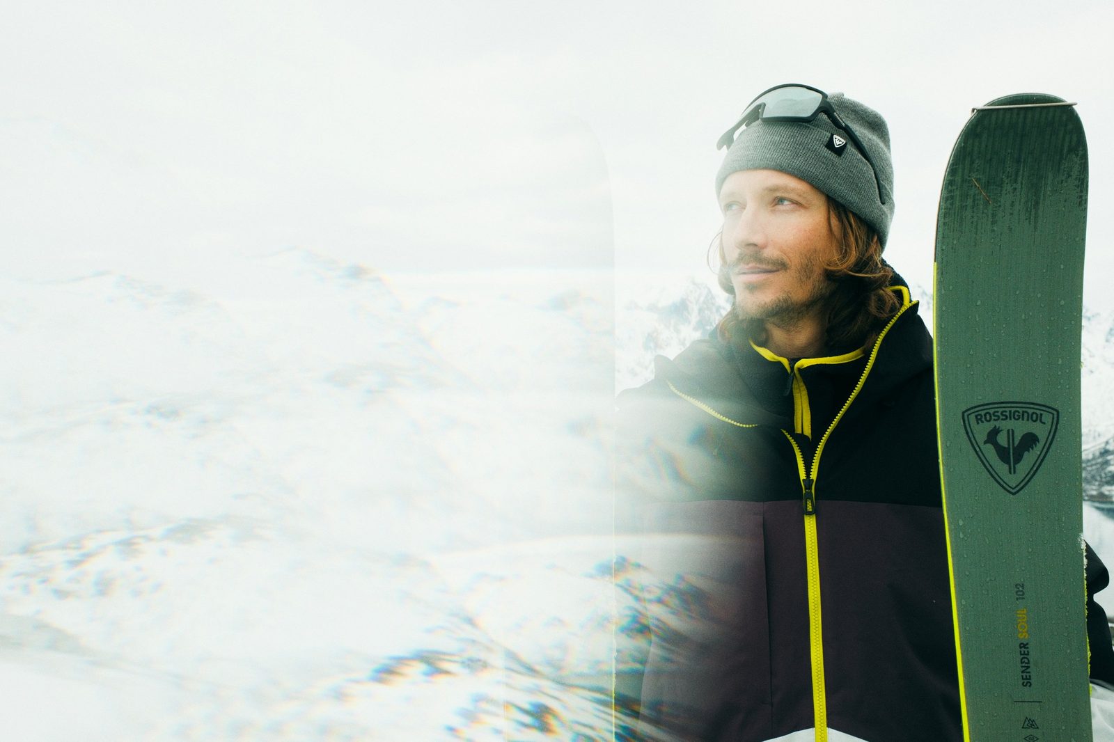 Skier holding skis in the mountains