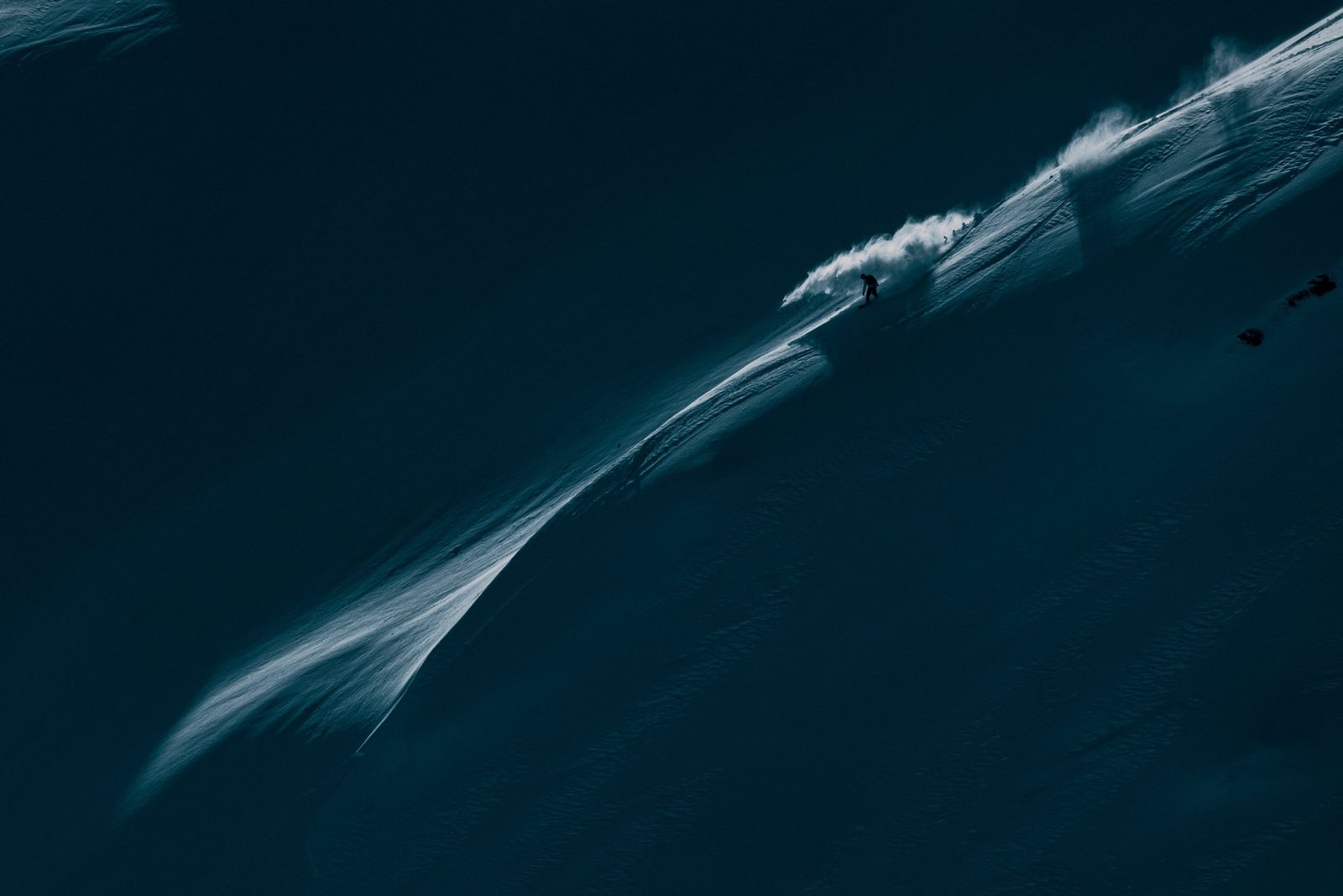 Snowboarder on a shadowed ridge